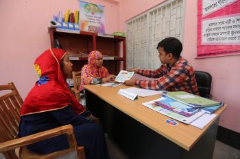 A Village Court Assistant consults with villagers about services of Village Courts